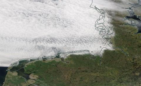 Cloudy over sea and clear sky over land